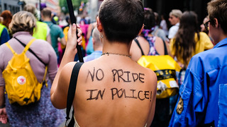 A person's back with 'No Pride in Police' written on it