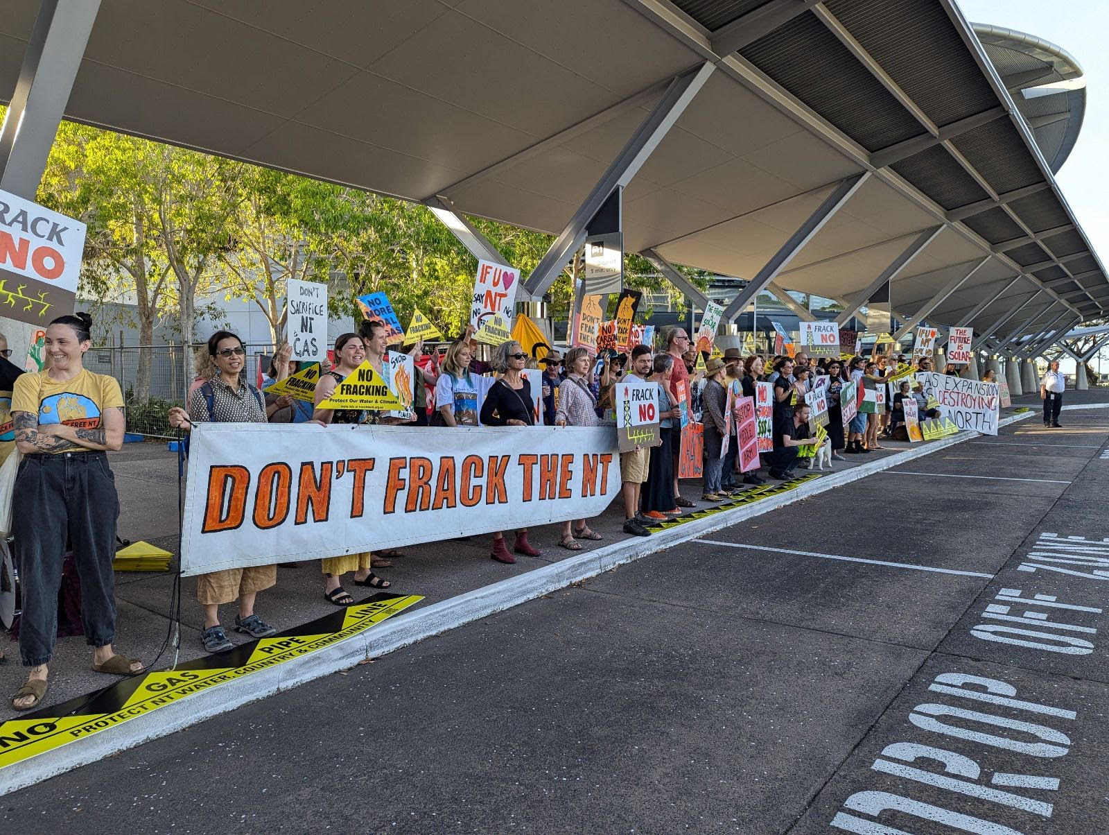 More than 100 community members protesting out front of NT Resources Week at Darwin Convention Centre.