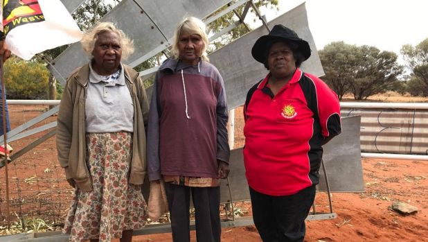 Shirley Wonyabong, Elizabeth Wonyabong, and Vicky Abdullah, standing in front of entrance to Yeelirrie Pastoral lease gates