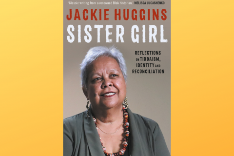 Book cover for Dr Jackie Huggins' 'Sister Girl' set against an ombre yellow background. The cover features a head shot of Dr Huggins, who has medium-brown skin and short white hair, and is wearing an olive-green blazer over a black top. She is also wearing a pair of dangling snake-shaped earrings decorated with dotwork art, and a colourful chunky necklace made of decorated large beads and small red seeds strung together. The cover also includes the book title, author name, and review by Melissa Lucashenko.