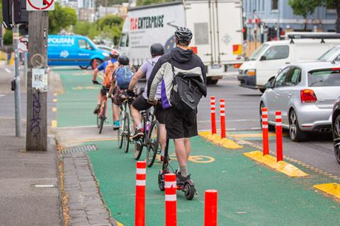 Bicycle and scooter riders waiting in a protected lane. Image credit: Yarra City Council