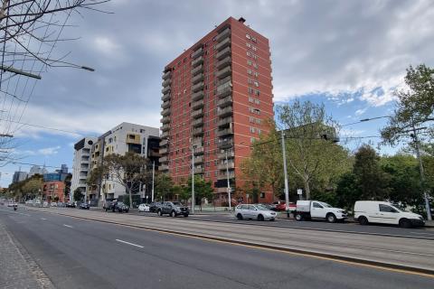 A photograph of the empty red-brick public housing tower in Carlton on Nicholson Street, taken from across the road.