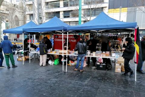 Community Union Defence League's street kitchen in the CBD- a stall under two marquees with volunteers handing out food.