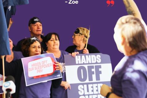 Hands Off Sleepover Pay! Rally of people with signs wearing purple and eye masks demanding hands off sleepover pay.