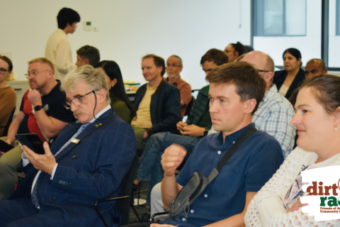 Image of audience members at watching a speaker at the community forum