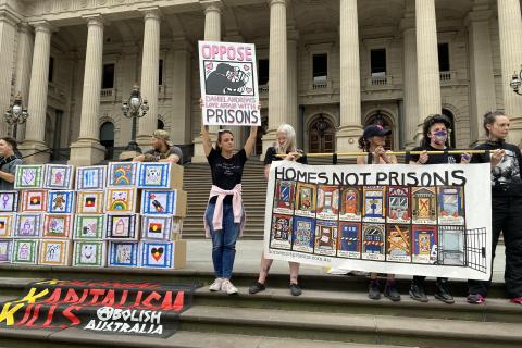 Homes not Prisons banners saying Homes Not Prisons and Oppose Dan Andrew's Love affair with Prisons on the steps of Parliament Naarm/Melbourne Oct 2022