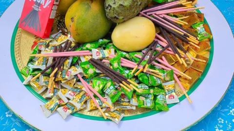 A large plate offering pocky biscuits, mango, dragon fruit, soursop and lollies 