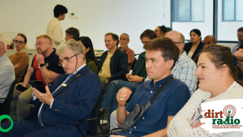 Image of audience members at watching a speaker at the community forum