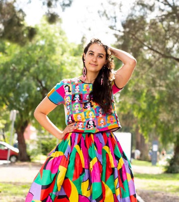 Colourful portrait of Kate Robinson standing on train tracks in Footscray.