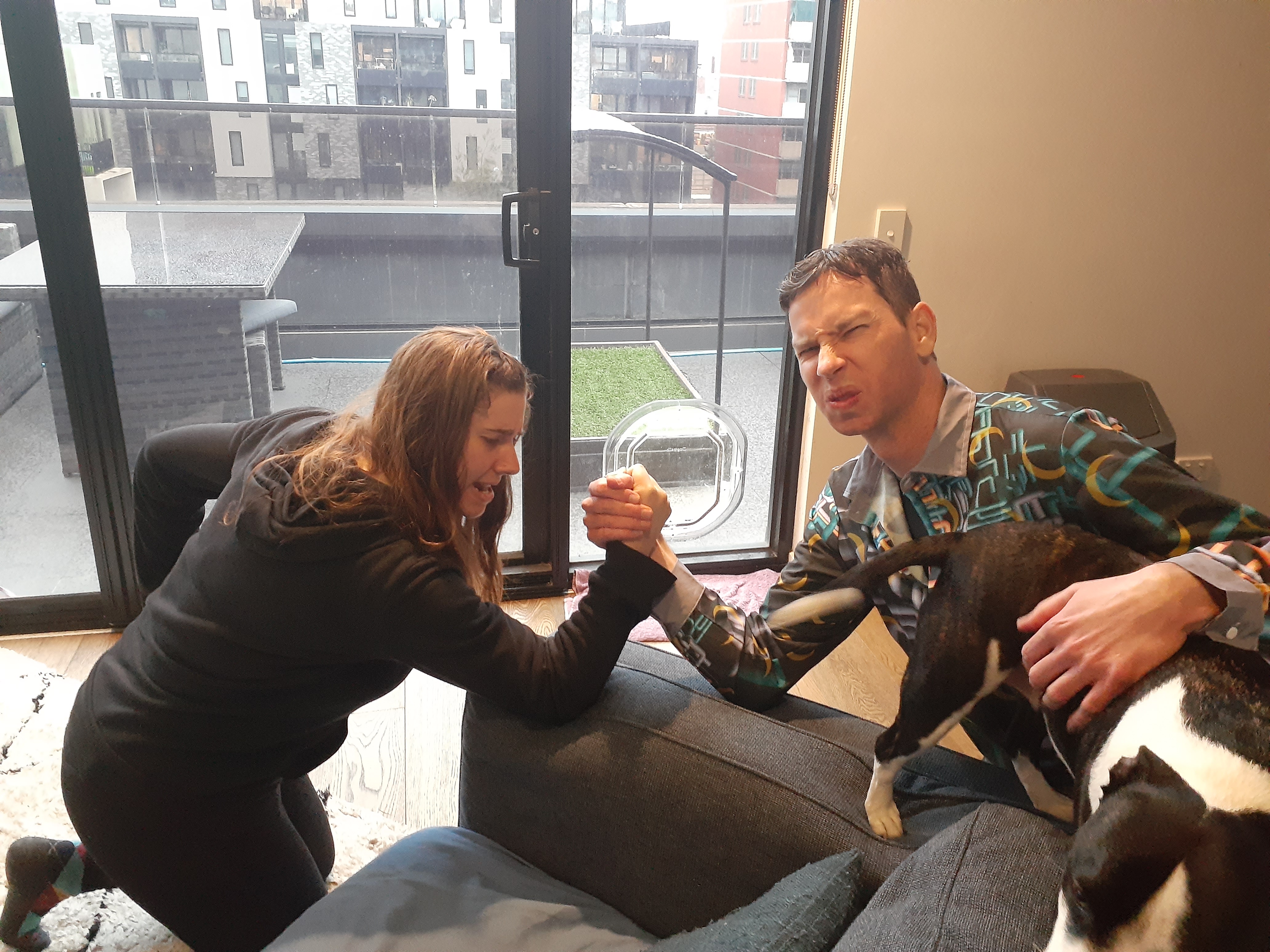 Lottie and Nick arm wrestling.