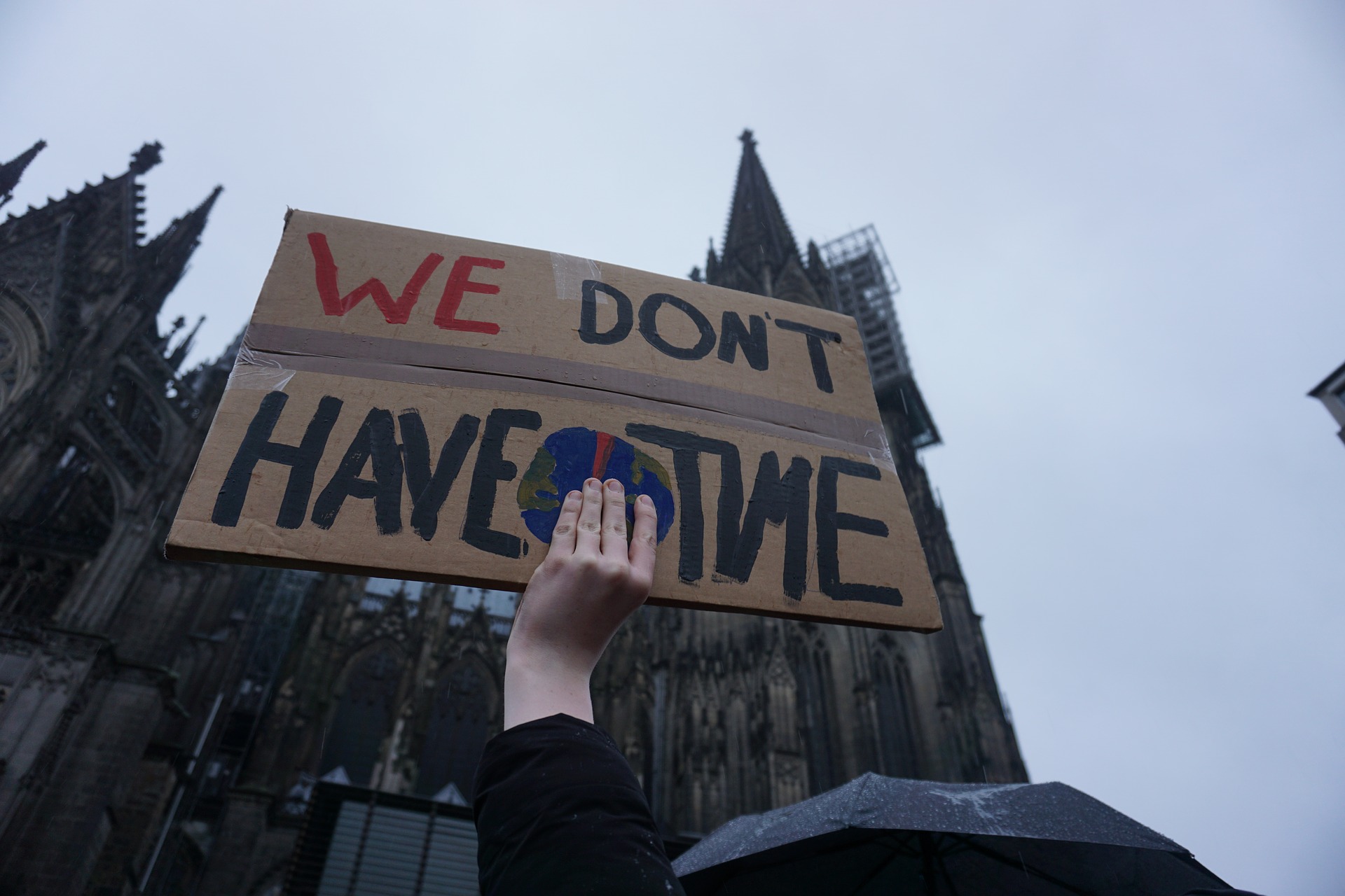 Photo of a climate rally with a banner reading: We don’t have time.