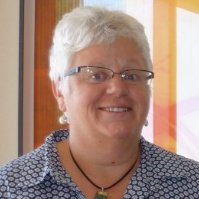 Dr Chris Atmore from Environmental Justice Australia. Photo of a woman from the shoulders up. Woman has white hair, is wearing a blue collared shirt, glasses and is smiling.