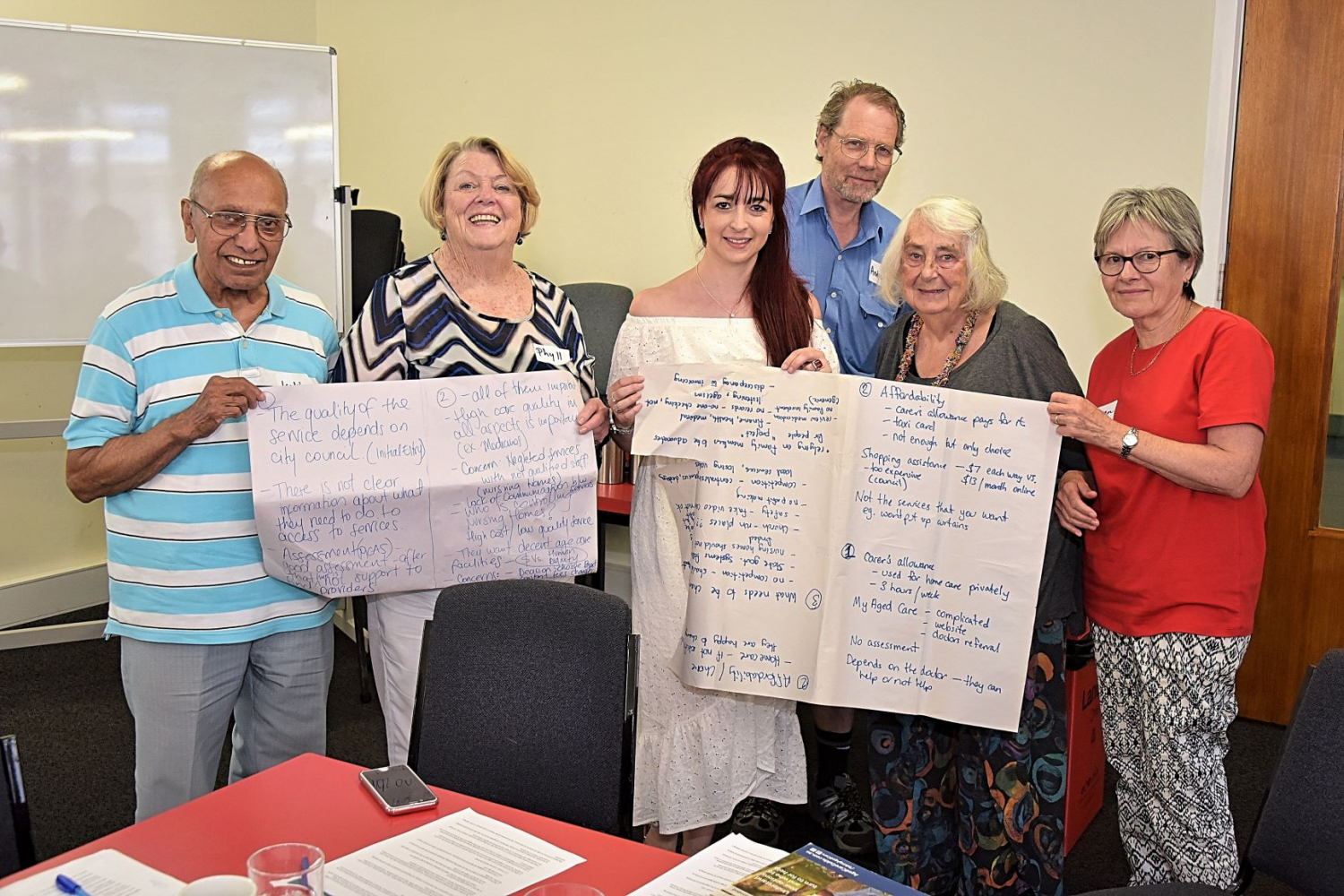 A group of HAAG members hold up butchers paper they've used for brainstorming