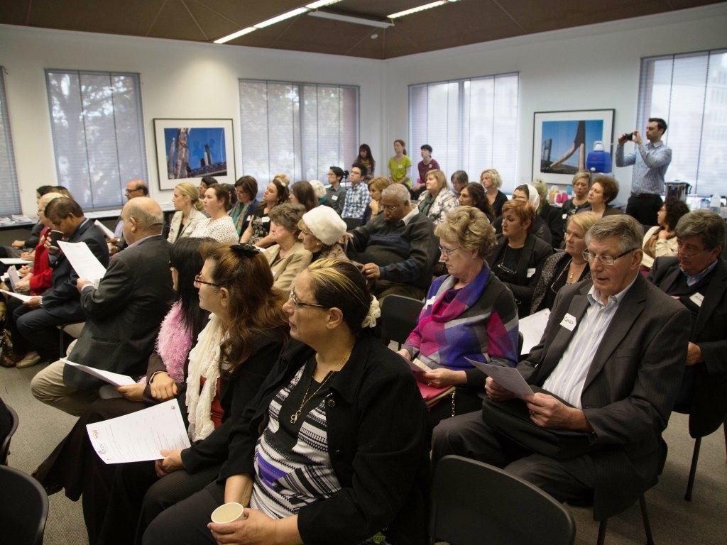 Older renters watching a presentation at the HAAG/ECCV project launch, Preventing Homelessness in Older CALD Communities