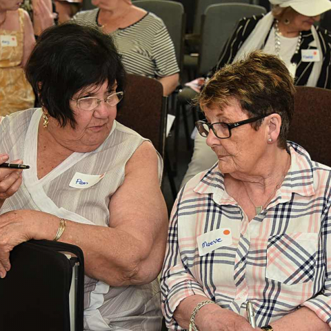 Two dark haired women sit side by side