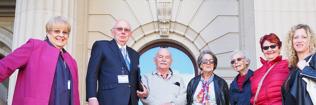 A group of retirement housing residents and advocates stand on the steps of Parliament House.