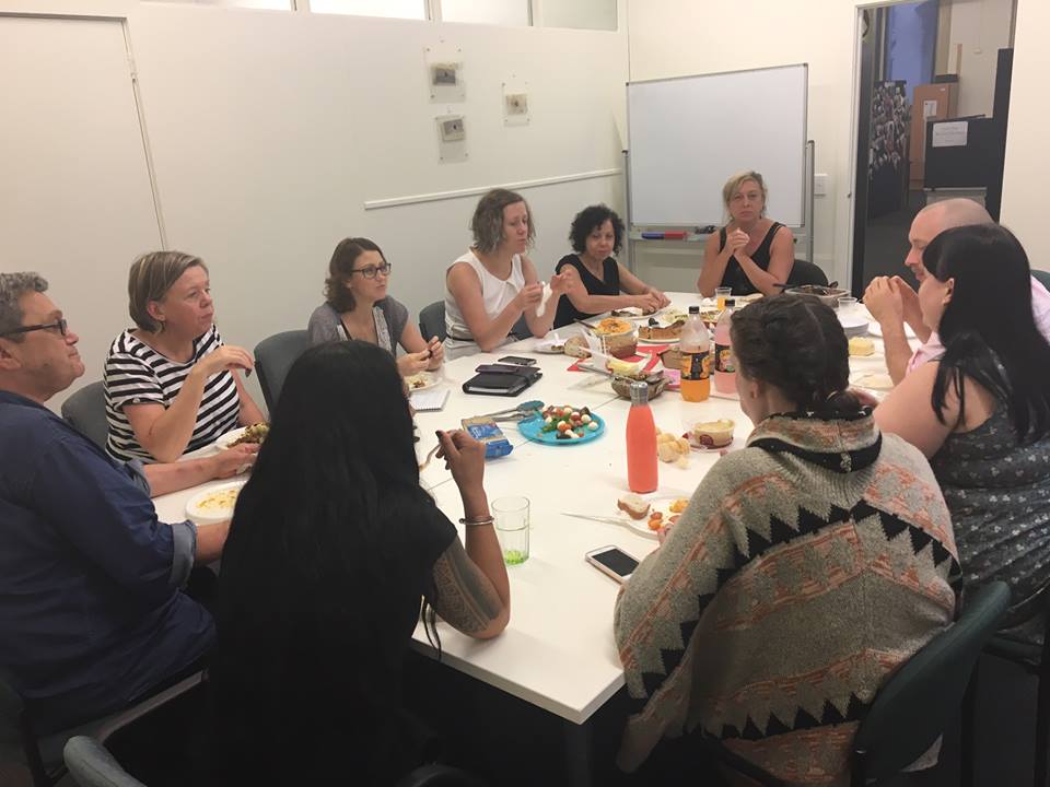 A group of workers sitting around a table in a meeting room