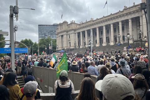 Image of big crowd at invasion day rally and Parliament house in the background