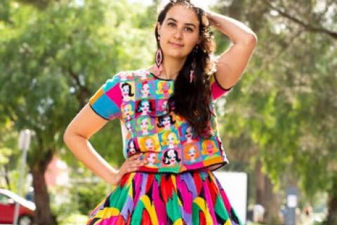 Colourful portrait of Kate Robinson standing on train tracks in Footscray.