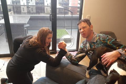 Lottie and Nick arm wrestling.