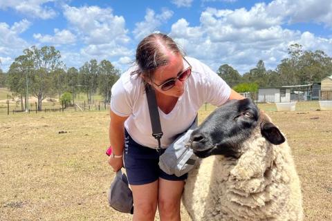 Rachel standing next to a sheep in a paddock