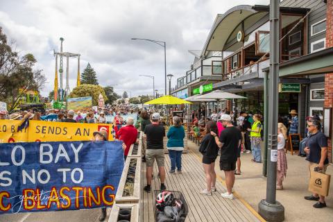 People marching in the street with sign saying 'No to Blasting'