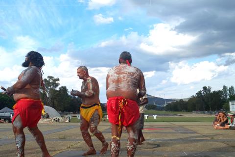 Three  painted up dancers dancing.