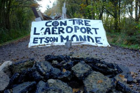 A barricade at the Notre-Dame-des-Landes ZAD. Banner reads: AGAINST THE AIRPORT AND ITS WORLD