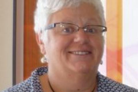 Dr Chris Atmore from Environmental Justice Australia. Photo of a woman from the shoulders up. Woman has white hair, is wearing a blue collared shirt, glasses and is smiling.