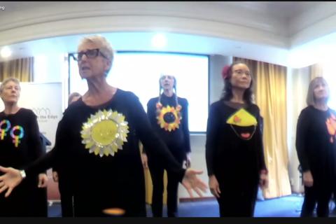 A group of five older women singing as a group