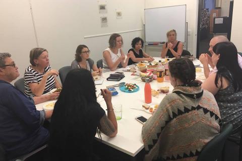 A group of workers sitting around a table in a meeting room