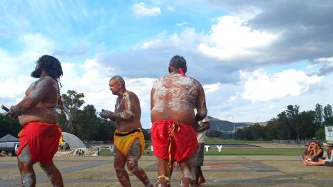 Three  painted up dancers dancing.